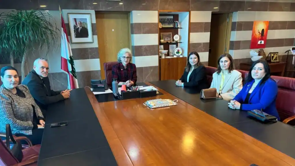 Rima Karameh sitting in the middle of a meeting discussing the possible relocating of displaced families 